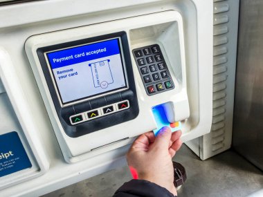 Kidderminster, Worcestershire, İngiltere, ABD - 7 Nisan 2022: Tesco dolum istasyonu müşterisi benzin pompasını kullanmadan önce yakıt parasını bankamatik kartıyla ödüyor.