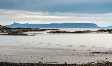 İskoçya İskoçya 'nın uzak ve huzurlu batı sahillerinde güzel bir kumlu sahil, uzak dağların silueti. Alacakaranlıkta, yaz akşamının sonunda..