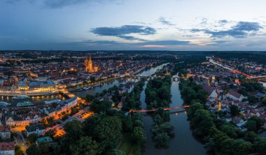 Tuna nehri ile Bavyera 'daki Regensburg şehrinin panoraması aydınlanmış katedral ve Almanya' nın alacakaranlık saatinde yazın mavi saatte taş köprü.