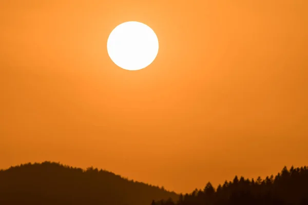 Zblízka Slunce Při Západu Slunce Nad Horizontem Horskou Kopcovitou Krajinou — Stock fotografie