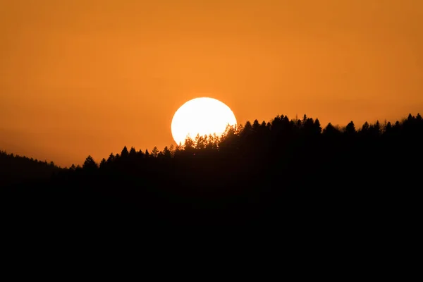 Zblízka Slunce Při Západu Slunce Nad Horizontem Horskou Kopcovitou Krajinou — Stock fotografie