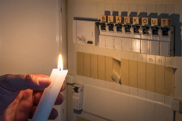 在停电时 用白色蜡烛点燃保险丝盒 并在配电箱里装上保险丝 — 图库照片