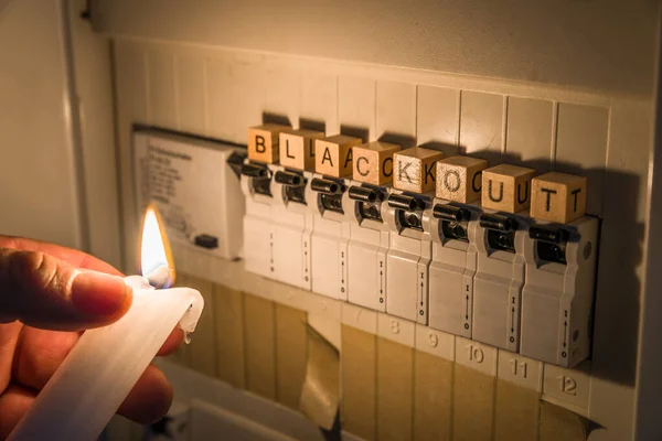 在停电时 用白色蜡烛点燃保险丝盒 并在配电箱里装上保险丝 免版税图库图片