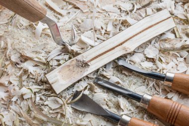 Kendi kendine oyulmuş ahşap kaşık pişirme kaşığı çatal bıçak ile çalışılmış tezgah üzerinde ahşap parçacıklar, Almanya