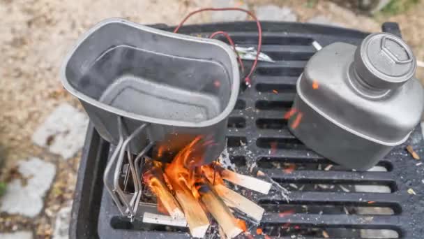 チタンマグカップでステンレス製のホボストーブを燃焼させる映像は ドイツ 屋外のバーベキューで水を沸かします — ストック動画