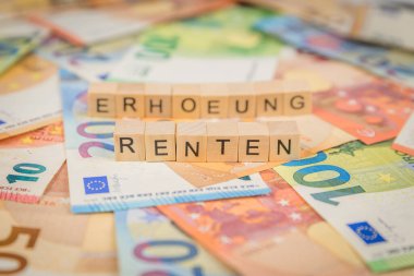 Renten kelimesi - Almanca yıllık ödeme için - ve Erhoehung - Almanca yükseltme için - tahtadan zar metniyle yazılmış Euro notlarının arka planında