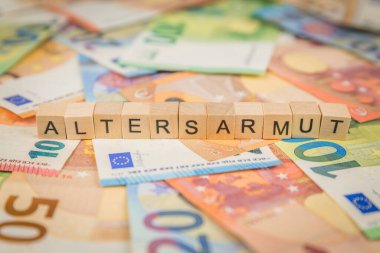 Altersarmut kelimesi - yaşlılık yoksulluğu için Almanca - banknotların üzerine ahşap küp metinlerle Euro notları ile yazılmıştır.