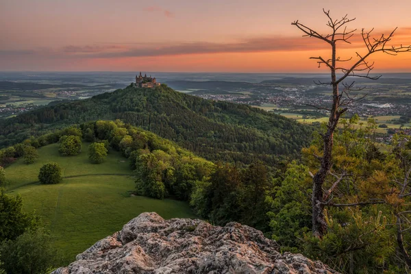 Sunrise at Zeller Horn with view to medieval knight castle Burg Hohenzollern with beautiful colored clouds in the sky in autumn in Bisingen Hechingen, Germany