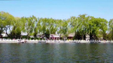 Pekin 'in Shichahai su yüzeyi yavaş hareket ediyor. Bazı insanlar yüzüyor ve bazı ördek tekneleri. Önünüzdeki resim tipik bir Pekin manzarası.