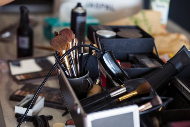 Makyaj sanatçısının masasına bir sürü makyaj malzemesi ile odaklanmış bir dönüştürücü. Makyaj sanatçısının masasını çevreleyen yığın mesaj için yer açıyor..