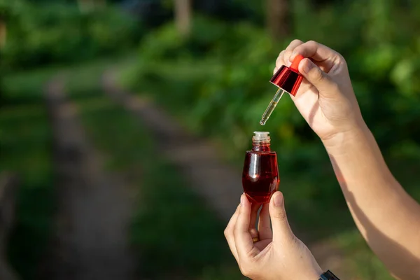 Foco Seletivo Garrafa Soro Facial Vermelho Mão Mulher Asiática Natureza — Fotografia de Stock