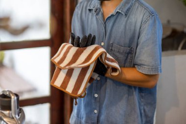 Kafe çalışanlarının ellerine seçici bir şekilde odaklanan siyah lastik eldiven takan barista ellerini her zaman kurulamak için bir havlu kullanıyor. Yemek malzemesi ve temiz yiyecek ve içecek yapmak için.