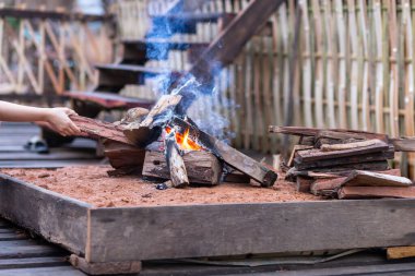 Kış kampı için ahşap evin önündeki avluda şenlik ateşi. Tayland 'daki dağ kabilelerinin evlerinde kamp yapmak için şömine ve şöminelere ihtiyacımız var..