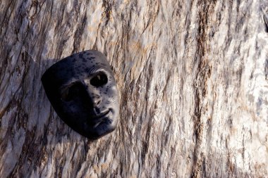 Seçici odaklı siyah plastik maske güzel desenli bir taşın üzerine yerleştirilmiş. Güçlü bir his verir ve karanlık güçler kavramına sahiptir. İnsanın karanlık tarafı. Metin için yer vardır..