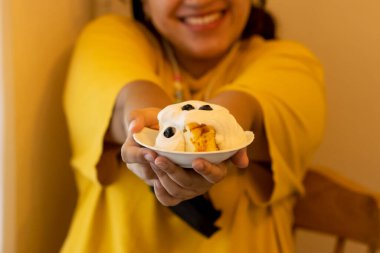 Üzerine beyaz kremalı yaban mersini ezmesi sürülmüş, tatlı seven şişman bir kadının ellerinde seçici odaklı cheesecake peyniri. Peynirli kek yemekten mutluluk duyarım..