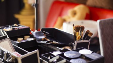 Makyaj sanatçısının masasına bir sürü makyaj malzemesi ile odaklanmış bir dönüştürücü. Makyaj sanatçısının masasını çevreleyen yığın mesaj için yer açıyor..
