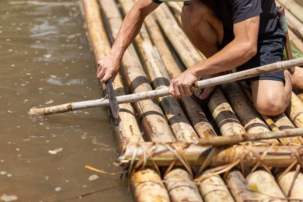 Seçici odak Tayland 'da bambu salları yapmak için bambu kesen bir köylünün eli bambu kullanıyor.