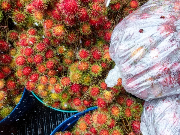 Rambutan fruit in Thailand is in the back of a truck to buy fruit from farmers. Water on the surface of the fruit as they have to travel long distances to bring fresh fruit to the market.