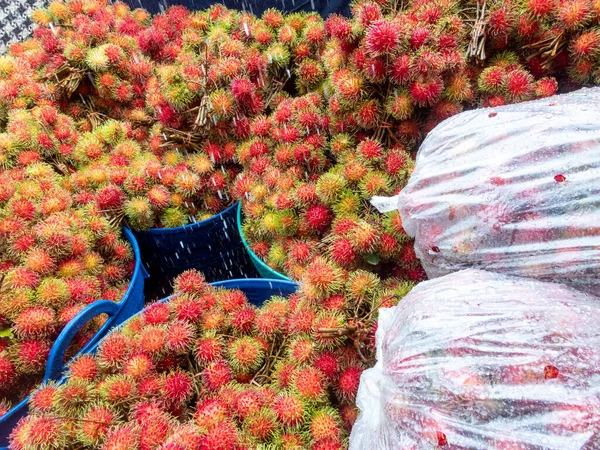 Rambutan fruit in Thailand is in the back of a truck to buy fruit from farmers. Water on the surface of the fruit as they have to travel long distances to bring fresh fruit to the market.