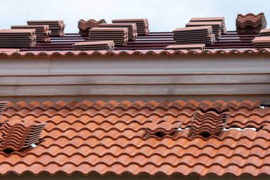 Binanın yeni çatısını inşa etmek için çatıya kalın turuncu fayanslar yerleştiriliyor..