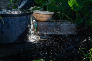 Su tankı taşar çünkü su musluğu açık kalır. Su tasarrufu hakkında doğa koruma kavramı