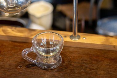Küçük şeffaf cam, temiz kahve fincanı, ahşap masaya saplı.