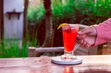 Limonlu yoğurtla karıştırılmış berrak bardakta çilek içeceği, üstüne konur. Ve kadının eli...