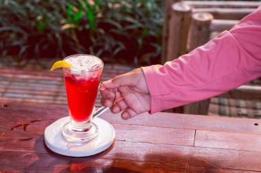 Limonlu yoğurtla karıştırılmış berrak bardakta çilek içeceği, üstüne konur. Ve kadının eli...