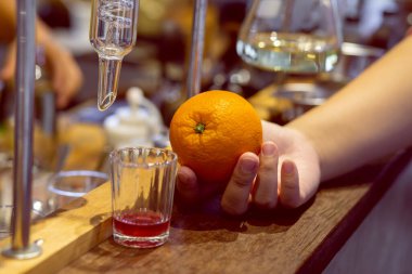 Laboratuvardaki kadınların elindeki portakalları kapat. Meyve suları için en iyi ve mükemmel formülü geliştirmek için.