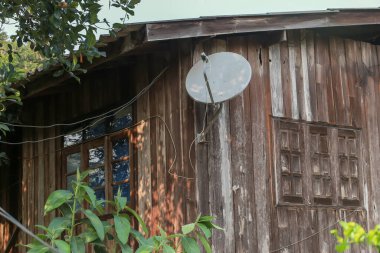 Eski ahşap eve takılmış eski bir TV alıcısı plakası. Ev modeli, Tayland tarzı tasarım.