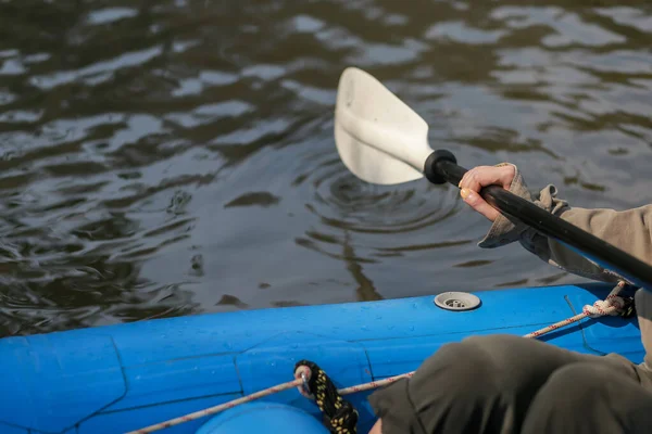 一个女人在一条蓝色的橡皮艇上拿着桨在白河中漂流 这是在大自然的身边进行的休闲活动 — 图库照片