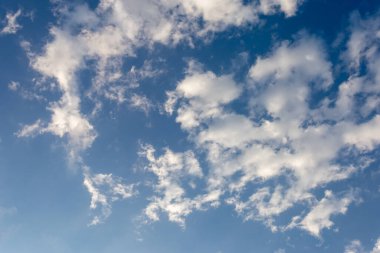 Yüzen bir sürü güzel beyaz bulut ve bulutların arasında parlayan parlak mavi gökyüzü var. Mavi arkaplan tasarımı için gökyüzü görüntüleri sizi taze ve parlak hissettirir.