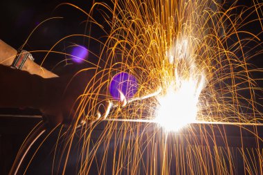 Close-up Iron welding close-up, sparks do not wear gloves. Welding sparks and fumes It can be dangerous to health. Welding of steel fireworks.	