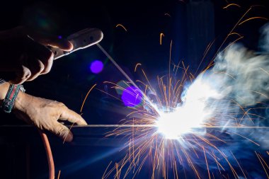 Close-up Iron welding close-up, sparks do not wear gloves. Welding sparks and fumes It can be dangerous to health. Welding of steel fireworks.	