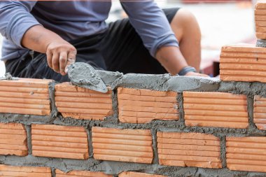 Duvarcı eliyle turuncu tuğlaları kapatıyoruz evin duvarlarını inşa ediyoruz, duvarları oluşturmak için tuğla dizayn ediyoruz.