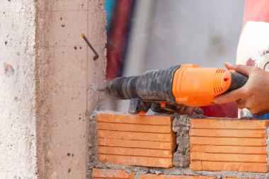 İnşaat işçileri tuğlaları örmek için inşaat demiri yerleştirmek için sütun yumruklama makineleri kullanıyorlar..