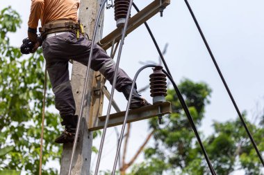 Elektrik direkleri elektrikçiler tarafından bağlanmak için kablo yerleştirilerek onarılıyor. Elektrik direklerinin üst kısmı yalıtıcıya bağlı. Yüksek faizli bir iş..