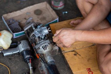 Küçük bir çim biçme makinesi Taylandlı bir tamirci tarafından sökülmüş. Çim biçme makinesi bir motosikletten uyarlanmış..