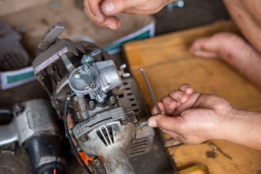 Küçük bir çim biçme makinesi Taylandlı bir tamirci tarafından sökülmüş. Çim biçme makinesi bir motosikletten uyarlanmış..