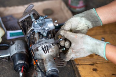Küçük bir çim biçme makinesi Taylandlı bir tamirci tarafından sökülmüş. Çim biçme makinesi bir motosikletten uyarlanmış..