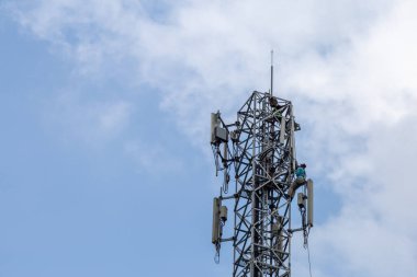 Bir telefon direğinin tepesindeki verici 4G 'den 5G' ye yükseltilmek üzere. Tayland 'da yüksek riskli elektrik mühendisi işi.