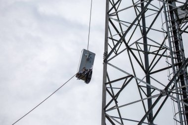 Anten 5G mobil ağ vericisi bir cep telefonu direğinin tepesine çekilmiş. Tayland 'da 4G' den 5G 'ye yükseltmek için yüksek riskli elektrik mühendisi
