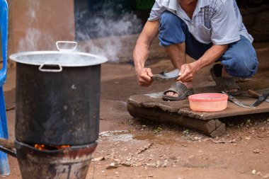 Seçici odak, kırsal kesimdeki köylülerin elleri bıçak yağdırıyor ve çiftliğe hayvanları getirmek için bir soba kuruyor. Aileleri ve arkadaşlarıyla yemek yapmak için..