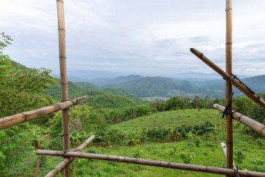 İnşa edilen evin önündeki manzaraya bak, bambu çerçevesini göster. Dağın tepesindeki evin önü güzel gökyüzü dağlarını görüyor musun?