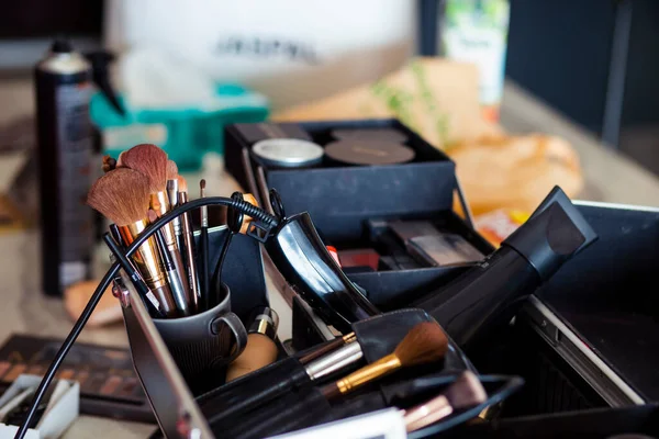 Dedicated focus Make-up converter on makeup artist\'s table with lots of makeup artist tools. The stack surrounds the makeup artist\'s table, leaving room for text.