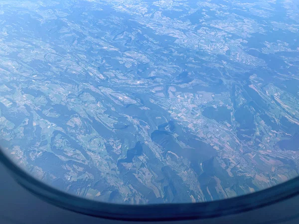 Airplane Window view on Earth by clear sunny weather from high altitude