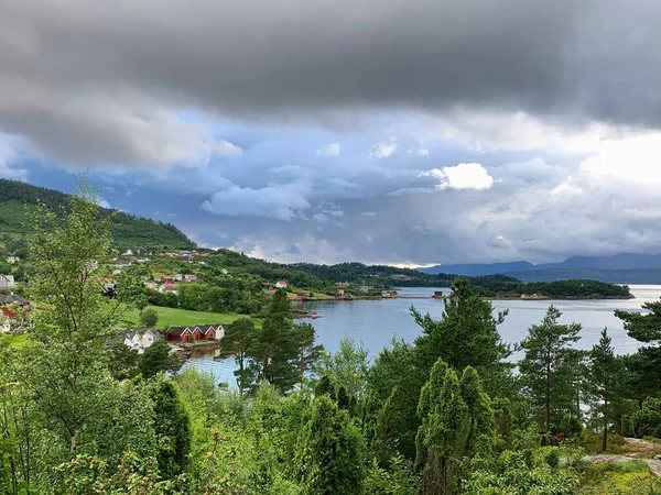 Norway fjords by summer with red traditional summer houses at the water's edge in a village