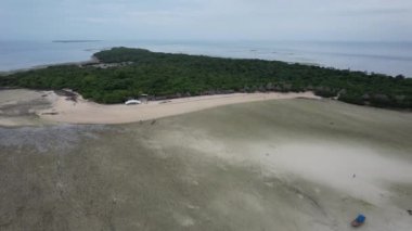 drone footage of a green island with sand and oeach, zanzibar