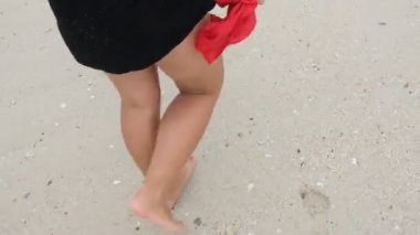 bir kumsalda yürüyen kadın
