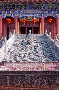 An incense burner and stone dragon carving in front of Tian Mu Chong Guang hall at Chan Yuan Temple in Tianmu shan area in Zhejiang province China. clipart